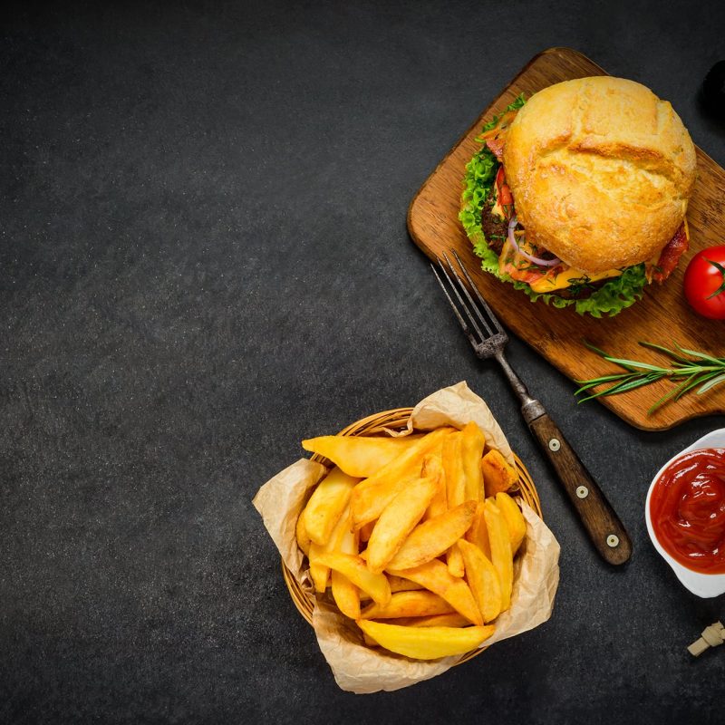 top-view-of-burger-with-french-fries-on-copy-space-PEYG7F6
